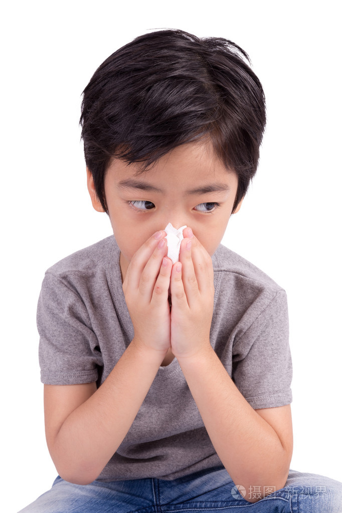 孩子用隔离在白色的纸巾清洁鼻子