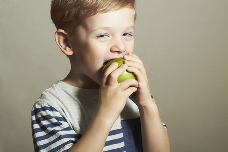 孩子吃 apple.little 英俊男孩青苹果。健康食品。水果。享受餐