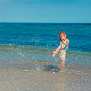 小女孩在一天的时间在沙滩上奔跑