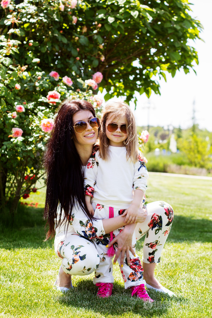 美丽的母亲和女儿躺在草地上