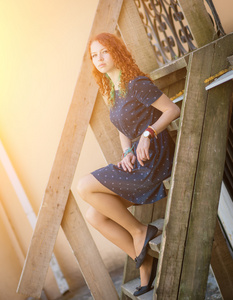 红发女孩坐在旧木楼梯上