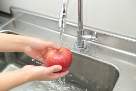 女人手洗苹果照片