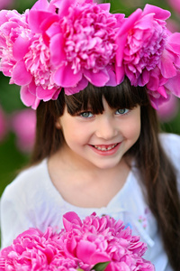 美丽的年轻女子的照片, 穿着捧花鲜花, 而步行户外通过薰衣草领域夏季