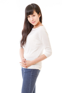 亚洲女人在白色紧身毛衣和蓝色牛仔裤，双手合在胸前