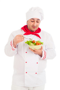 厨师控股菜与沙拉和新鲜蔬菜穿红色衣服