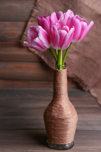 美丽的郁金香，在灰色的背景上桌上花瓶中的存储桶中