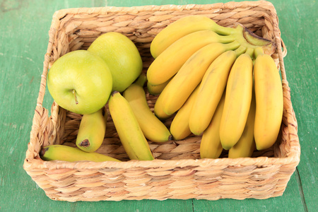 串色木背景上的柳条箱中的迷你香蕉