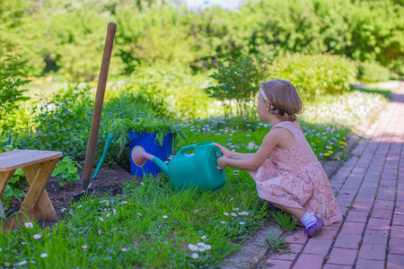 用喷壶在公园的小可爱女孩浇花