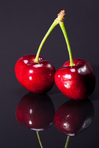 果实的成熟的红樱桃，深色背景上孤立