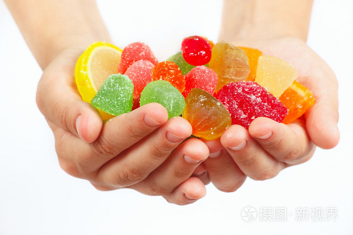 孩子手中五颜六色的水果糖果和果冻关闭