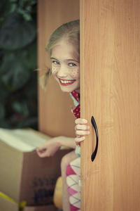 滑稽的女孩躲在衣柜里图片