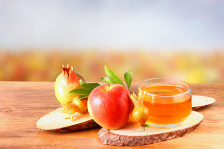 苹果蜂蜜和石榴在木桌