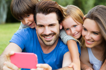 幸福年轻的家庭，与她的智能手机拍照以 par 的