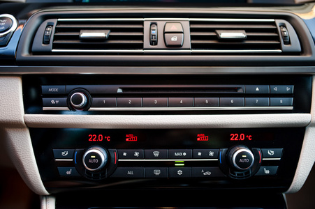 现代汽车内装用的空调和通风系统的特写镜头。极简主义的汽车内饰设计米色和黑色驾驶舱的细节