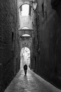 孤独的人，走在锡耶纳的小巷