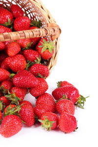 成熟的甜草莓在柳条篮子里，白色衬底上分离