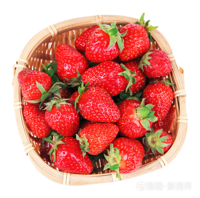 成熟的甜草莓在柳条篮子里白色衬底上分离