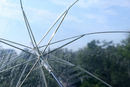 湿透明雨伞上天空背景照片