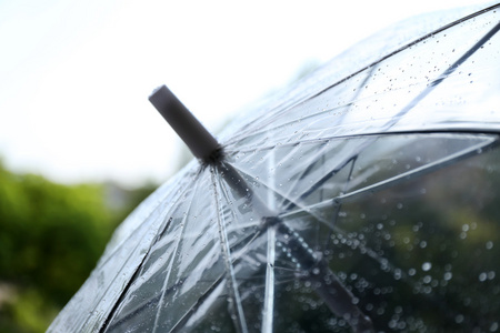 湿透明雨伞上天空背景秋天下雨的天气和一个年轻的人用雨伞年轻美丽的
