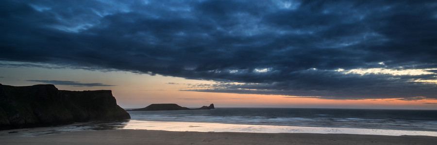 在与穆迪的天空日落景观全景 rhosilli 湾海滩