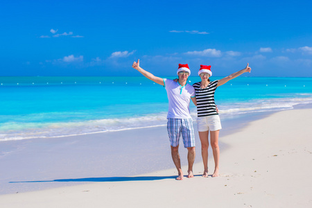 红色的圣诞帽的年轻快乐夫妇享受暑假