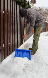 在暴风雪后从人行道上除雪的人