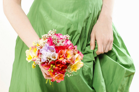年轻女子抱着花束的多彩小苍兰 f 的绿色礼服