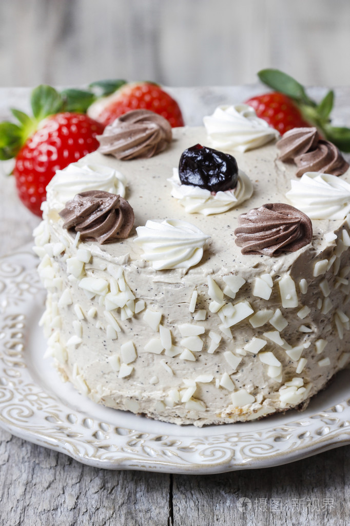 圆形的香草蛋糕蛋糕的立场上在后面的新鲜草莓