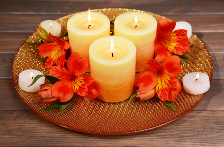 美丽的蜡烛，用鲜花上棕色背景表格