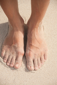 女子双脚在沙子里