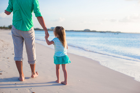 快乐的父亲和他可爱的小女儿在海滩