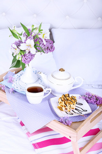 光在床上的早餐和美丽的花束