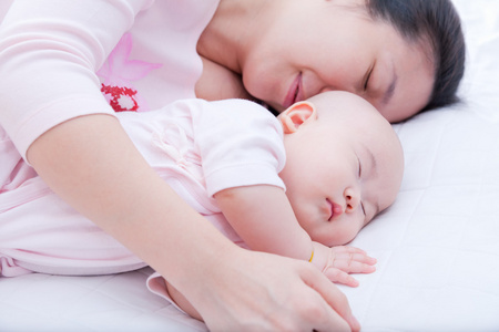 刚出生的婴儿女孩睡在母亲的手臂