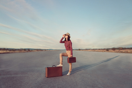 旅行者时髦女人看起来透过双筒望远镜