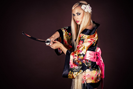 日本武士刀的女人年轻女子穿着裙子,身体,双腿,站在一个性感的姿势