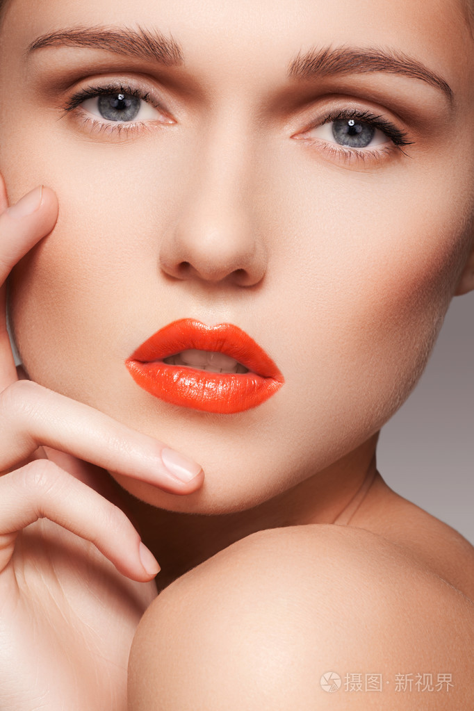 美丽的女人纯度着鲜红的嘴唇化妆的照片.可爱的模型与清洁光泽的皮肤