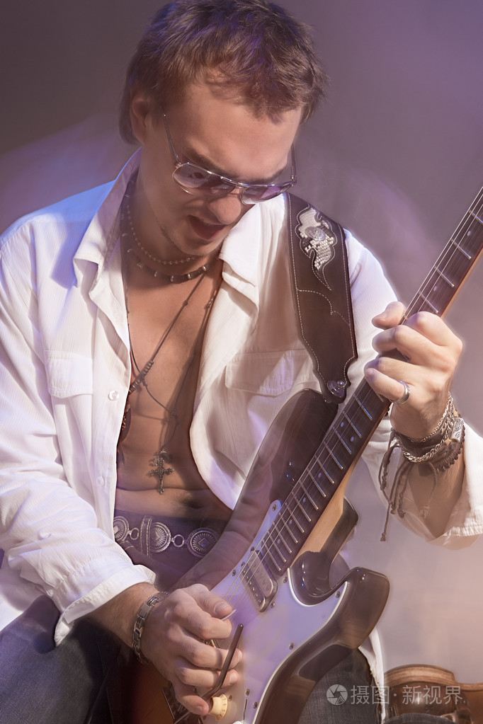 男性的吉他手弹电吉他.用闪光灯拍摄