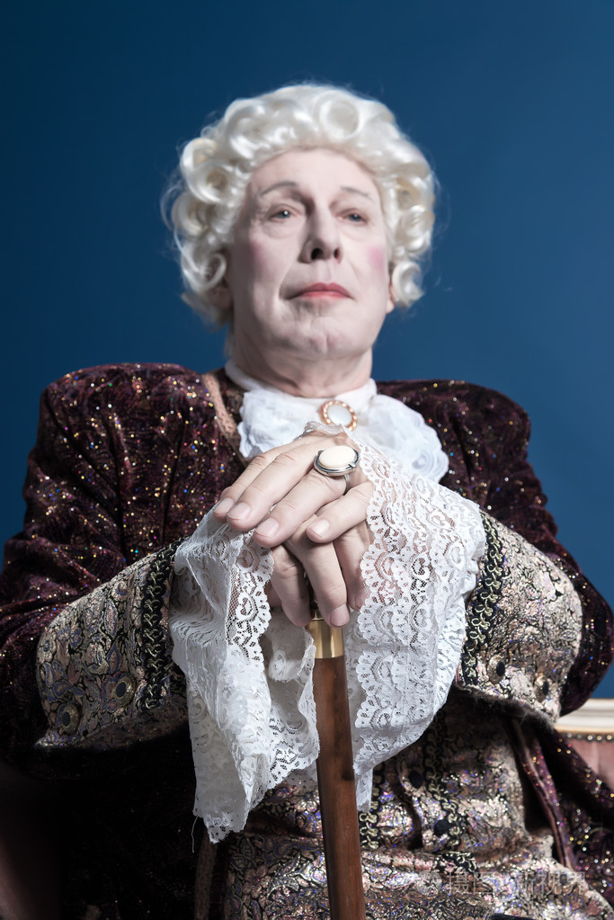 拿着拐杖坐的白色假发的复古巴洛克式男人