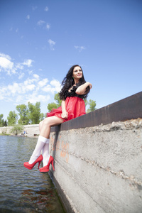 在河岸边的红裙子的女孩