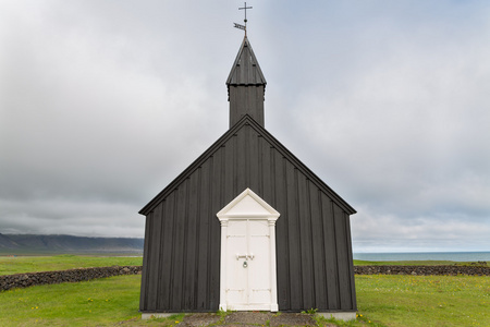 针对多云的天空，在 budir，冰岛的黑色木制教堂里的前面观