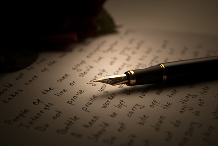 在文本与玫瑰的纸页上的钢笔