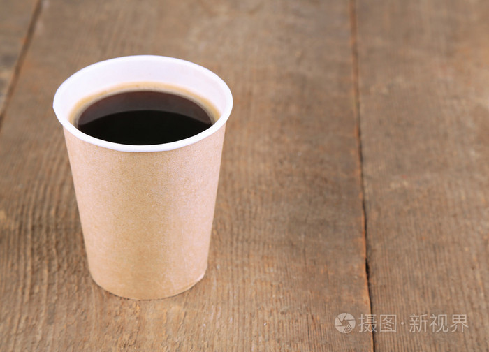 纸杯装的咖啡木制的桌子上