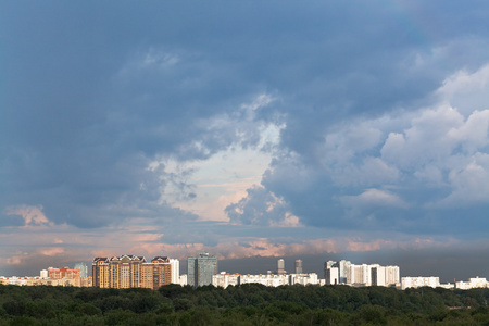 在城市上空的夕阳的天空下着雨乌云