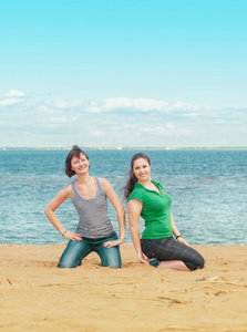 两个幸福的女人坐在沙滩上