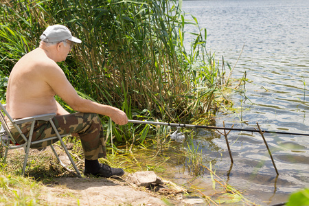 淡水的湖面上钓鱼的老人图片