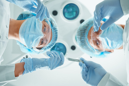 护士将一把手术刀传递给外科医生照片