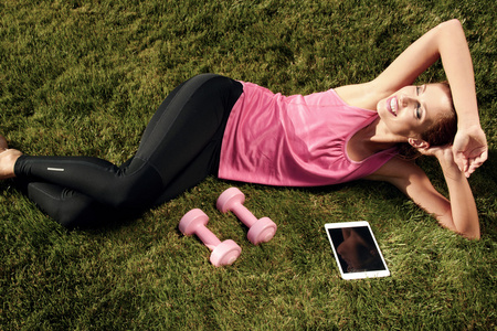 在公园里锻炼身体后休息的年轻女子