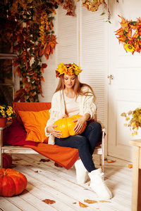 美丽的秋天女人微笑的黄色和橙色门廊上