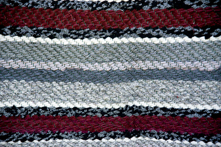 带编织的红色和灰色的地毯表面靠拢