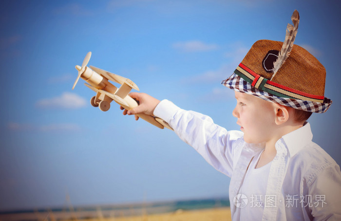 严肃的小男孩玩一个玩具飞机